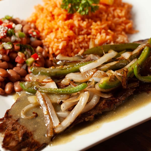 El Jardin's carne asada with grilled onions and peppers, served with rice and beans.
